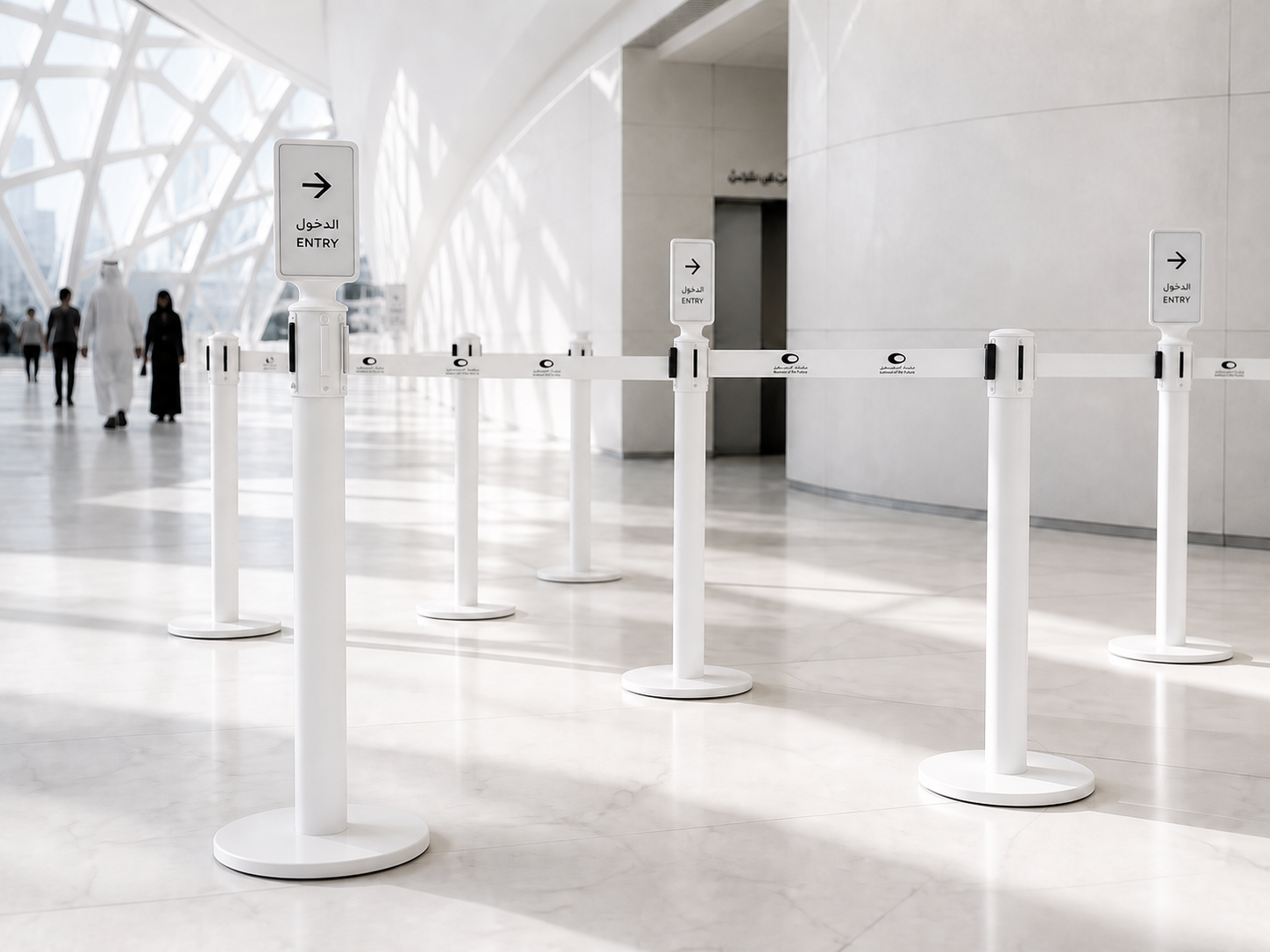 Bright museum queue with e-paper screens installed on only three strategic retractable-belt stanchions while the remaining posts stay standard